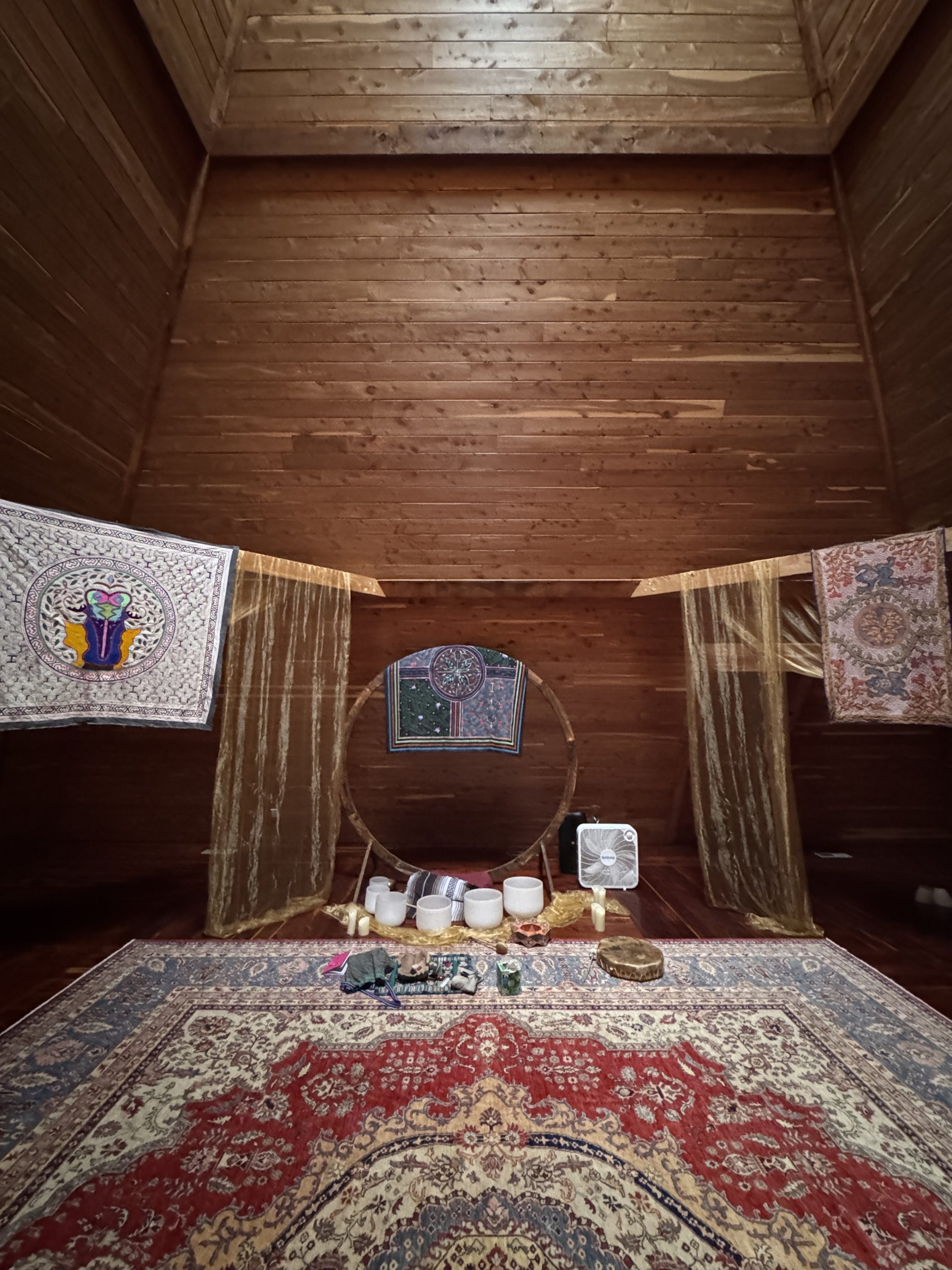 Inside the ceremony pyramid: layered Persian rugs and the circular altar