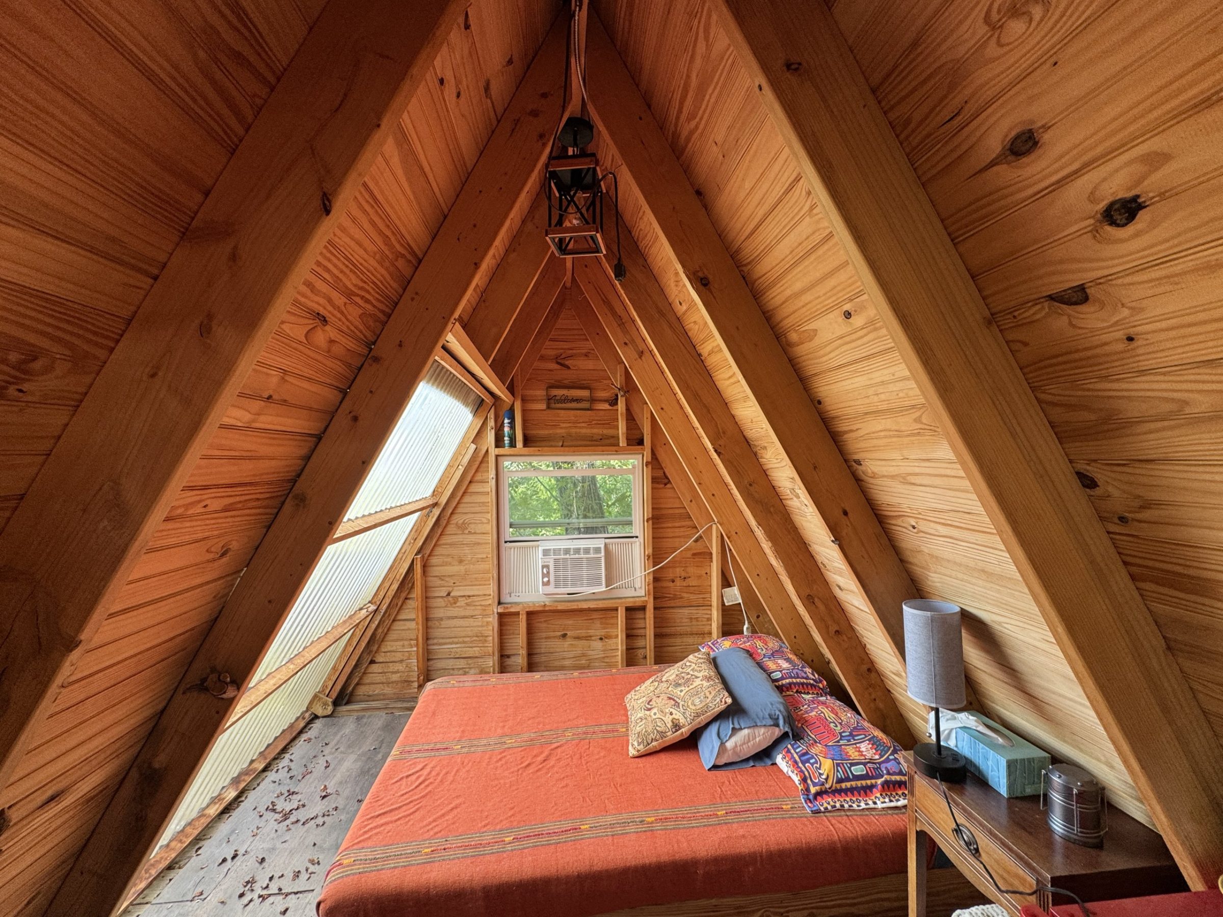 Inside a glamp: a bed under the A-frame ceiling