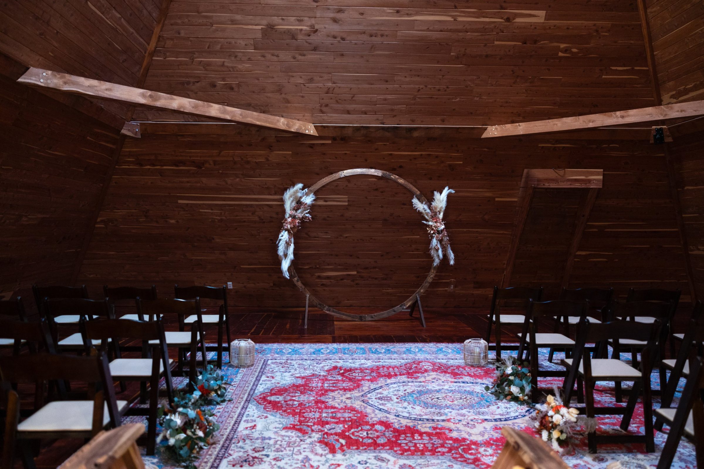 The circular wedding arch dressed with pampas inside the ceremony pyramid