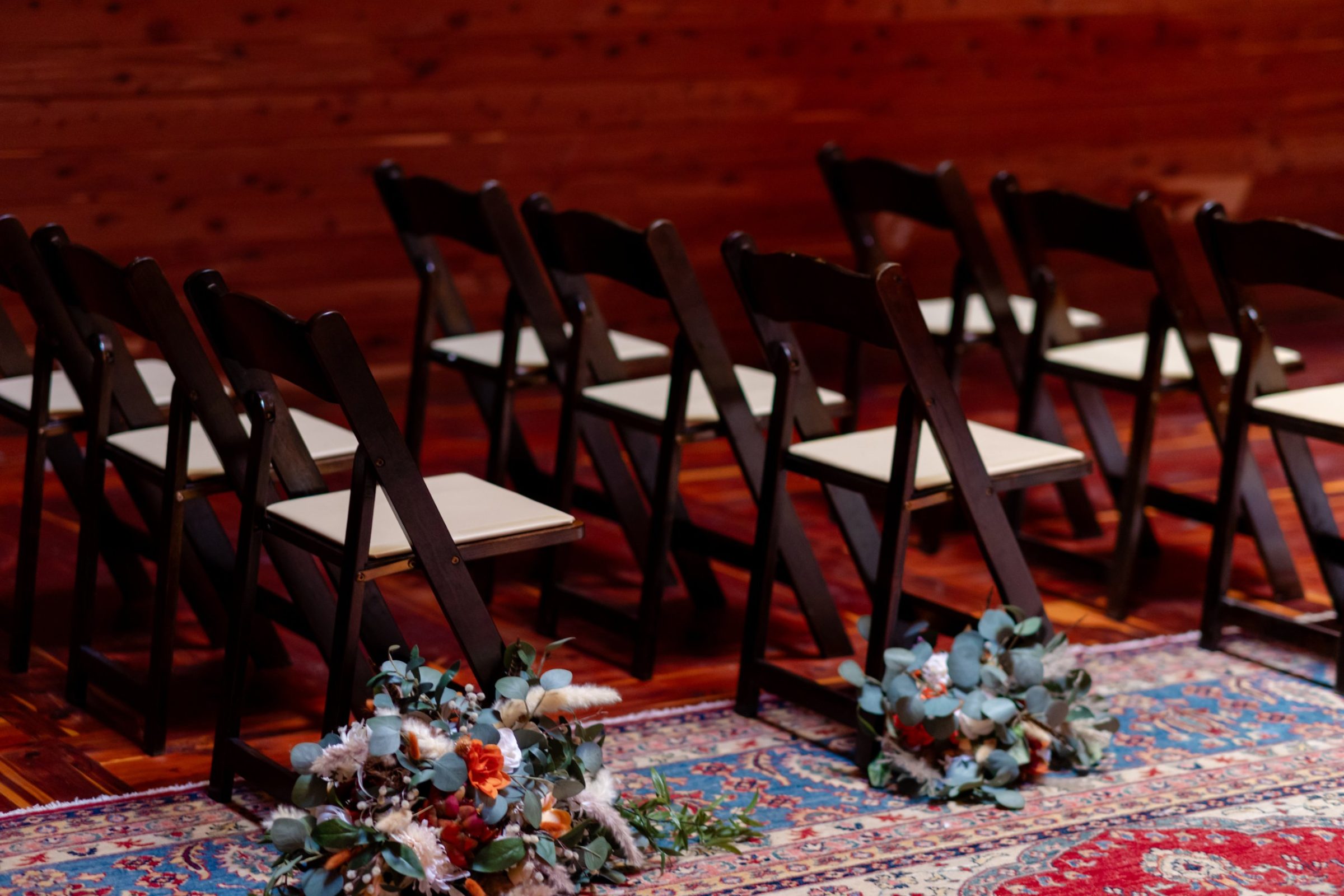 Ceremony chairs and aisle bouquets on the layered rugs
