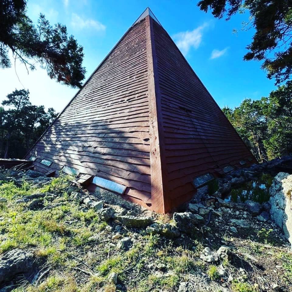 The finished cedar pyramid rising from the limestone hilltop