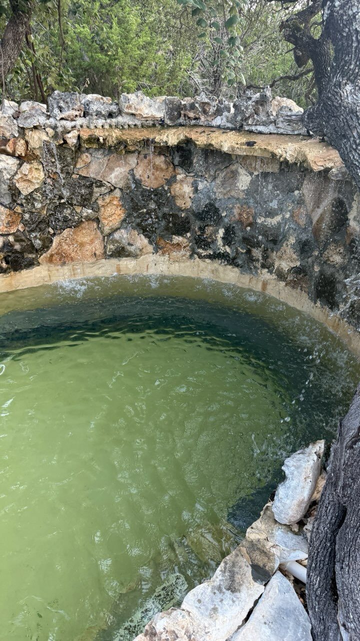 The stone hot tub tucked into the grotto corner
