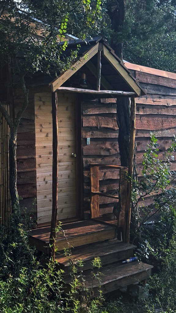 The cedar sauna hut in its bamboo-fenced grove